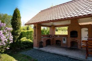 a brick building with a fireplace in a garden at Pensiunea Poiana Avrigului in Avrig