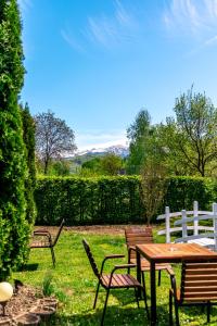 アヴリグにあるPensiunea Poiana Avriguluiの柵付きの庭のテーブルと椅子