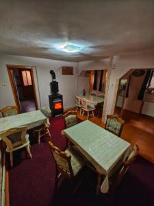 a living room with tables and chairs and a wood stove at Casa Miclau in Băile Herculane