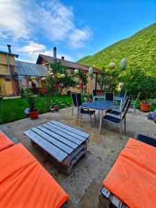 a patio with a blue table and chairs and a hill at Casa Miclau in Băile Herculane