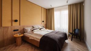 a hotel room with a bed and a chair at Apartamenty Sun & Snow Kossak Residence in Krakow