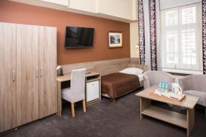 a hotel room with a bed and a tv at Hotel Maksymilian in Krakow