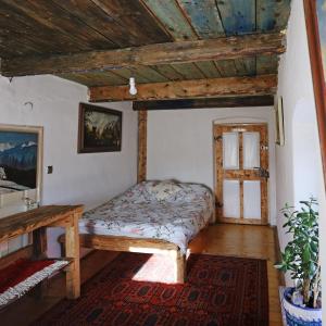 Siedlisko Pod Jaworem في Domaszków: غرفة نوم بسرير وسقف خشبي