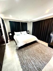 1 dormitorio con 1 cama grande y 1 alfombra grande en 3 Bedroom in Secure Estate Loadshedding free en Midrand