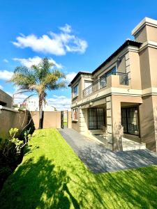 a large house with a palm tree in the yard at 3 Bedroom in Secure Estate Loadshedding free in Midrand