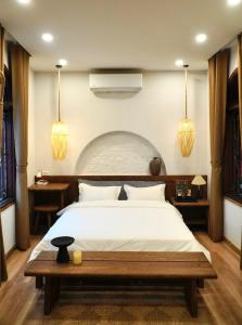a bedroom with a large bed and two pendant lights at The General's House in Hanoi