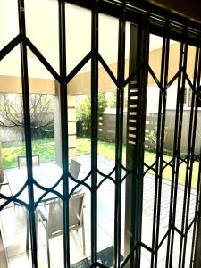 vistas a través de una ventana de cristal de un patio en 3 Bedroom in Secure Estate Loadshedding free en Midrand