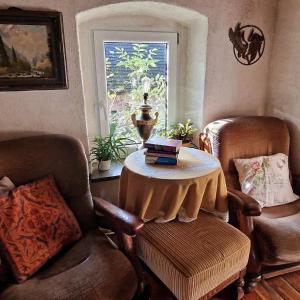Siedlisko Pod Jaworem في Domaszków: غرفة بها كرسيين وطاولة بها كتب