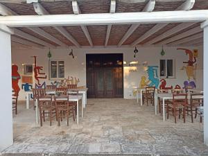 a dining room with tables and chairs and a mural at B&B La casa degli artisti in Ostuni