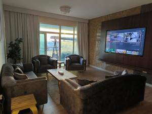 uma sala de estar com sofás e uma televisão de ecrã plano em شقة فخمة وواسعة غرفتين luxury and big 2BR em Ajman