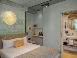 um quarto com uma cama grande e um lavatório em Hotel Louison em Paris
