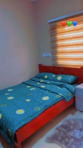 a bedroom with a bed with a blue comforter at Oyibi Saasabi Apartment in Oyibi