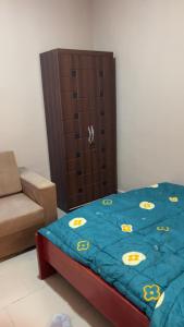 a bedroom with a bed and a brown cabinet at Oyibi Saasabi Apartment in Oyibi