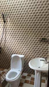 a bathroom with a toilet and a sink at Oyibi Saasabi Apartment in Oyibi