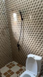 a shower stall with a toilet in a bathroom at Oyibi Saasabi Apartment in Oyibi