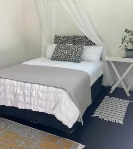 a bedroom with a bed with a canopy at Gecko Lodge, Dolphin Cottage in Vilanculos