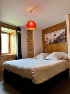 a bedroom with a large bed and a red light at Le refuge in Valloire