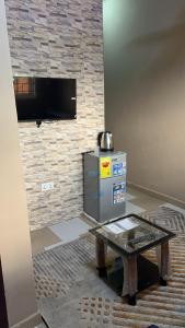 a living room with a table and a television at Oyibi Saasabi Apartment in Oyibi