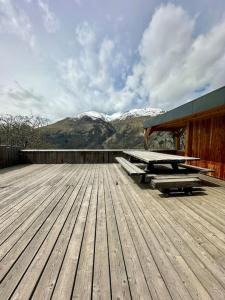 a deck with picnic tables and mountains in the background at Le refuge in Valloire