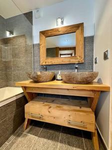 a bathroom with two sinks on a wooden counter with a mirror at Le refuge in Valloire