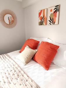 a bed with two orange pillows and a mirror at Charming Terrace Home in Whitchurch in Whitchurch