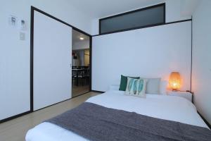 広島市にあるMitao bld - Huge 3 bedroom Apt 4mins walk PeacePark 6pplのベッドルーム(大きな白いベッド1台、ランプ付)