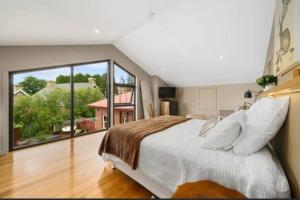a bedroom with a large bed and a large window at Hobart comfy studio in Hobart