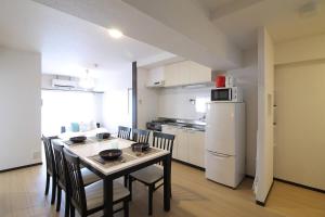 a kitchen and dining room with a table and chairs at Mitao bld - Huge 3 bedroom Apt 4mins walk PeacePark 6ppl in Hiroshima