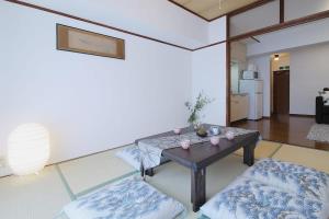 a living room with a table and a couch at Mitao bld - 2 Bedroom Apt 4mins to PeacePark for 9ppl in Hiroshima
