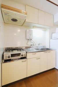 a white kitchen with a stove and a sink at Mitao bld - 2 Bedroom Apt 4mins to PeacePark for 9ppl in Hiroshima