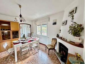 Una sala de estar con mesa y sillas y una chimenea. en Amazing view lago maggiore, en Cannobio