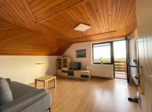 - un salon avec un canapé et un plafond en bois dans l'établissement Apartment Zupan, à Preddvor