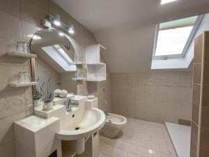 La salle de bains est pourvue d'un lavabo, de toilettes et d'une fenêtre. dans l'établissement Apartment Zupan, à Preddvor