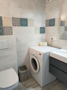 a bathroom with a washing machine and a sink at Les Arbousiers in La Croix-Valmer
