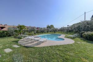 einen Pool mit 2 Stühlen und einem Tisch in der Unterkunft Villa Oleander in Manerba del Garda