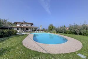ein Schwimmbad in einem Hof mit einem Haus im Hintergrund in der Unterkunft Villa Oleander in Manerba del Garda