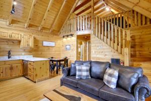 a living room with a couch in a log cabin at Pigeon Forge Vacation Rental with Private Hot Tub! in Pigeon Forge