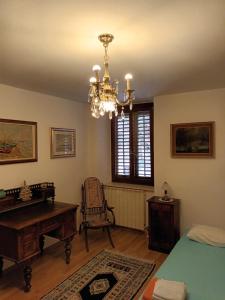 una camera con lampadario pendente, tavolo e sedia di Cosy house in historic centre a Izola