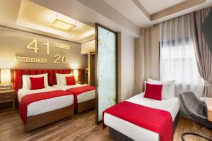 una camera d'albergo con due letti con accenti rossi di Ramada By Wyndham Istanbul Pera Taksim a Istanbul