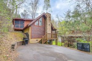 a log cabin with a porch and a deck at Pigeon Forge Vacation Rental with Private Hot Tub! in Pigeon Forge