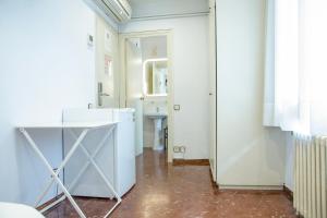 a hallway with white walls and a white refrigerator at Barcelona City Street in Barcelona