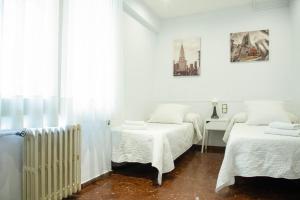 Habitación blanca con 2 camas y radiador en Barcelona City Street, en Barcelona