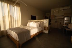 a bedroom with a large bed and a large window at ALS COMFORT SUITES in Preveza