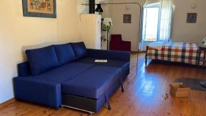 a blue couch sitting in a living room at Apartamento en Casa del Siglo XVI con caballos in Ametlla