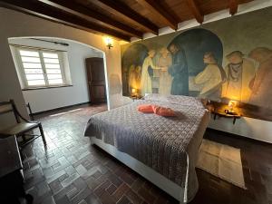 een slaapkamer met een schilderij aan de muur en een bed bij Residenza la Torre in Reno Di Leggiuno