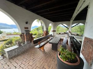 een patio met banken en uitzicht op het water bij Residenza la Torre in Reno Di Leggiuno