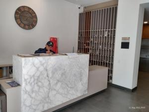 a man sitting at a marble counter with a phone at AC - Living 58 - Chapinero - Apartasuites in Bogotá