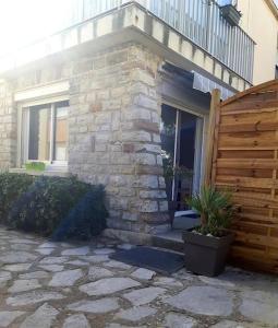uma casa com uma cerca de madeira e um pátio de pedra em Appartement 2 chambres, avec terrasse/parking em Palavas-les-Flots