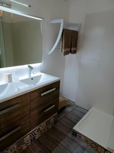 uma casa de banho com um lavatório, um WC e um espelho. em Appartement 2 chambres, avec terrasse/parking em Palavas-les-Flots