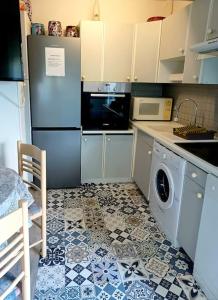 uma cozinha com um frigorífico e uma máquina de lavar roupa em Appartement 2 chambres, avec terrasse/parking em Palavas-les-Flots